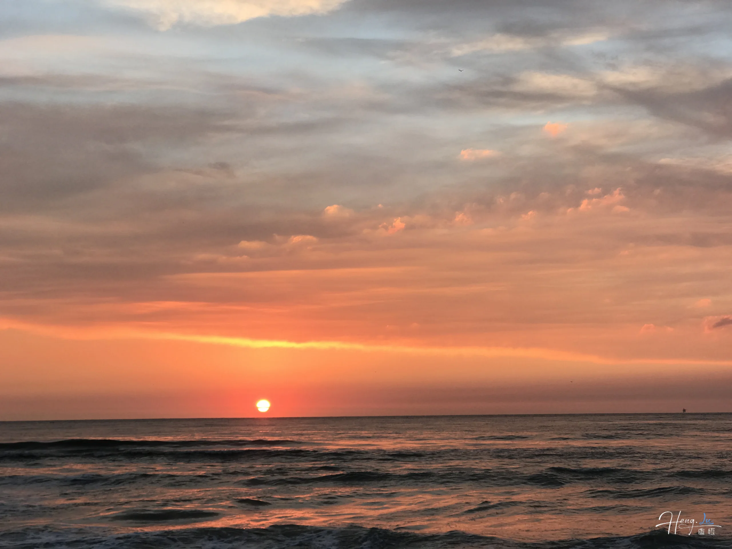 Orange sunset over peaceful ocean waves