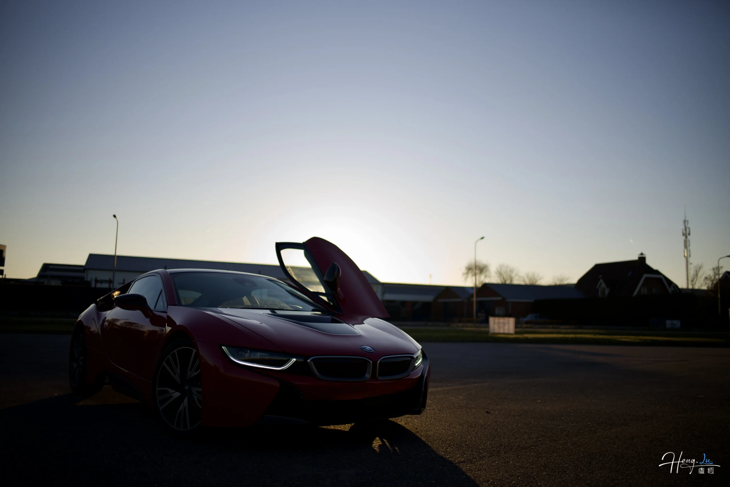 Red sports car parked under sunset sky