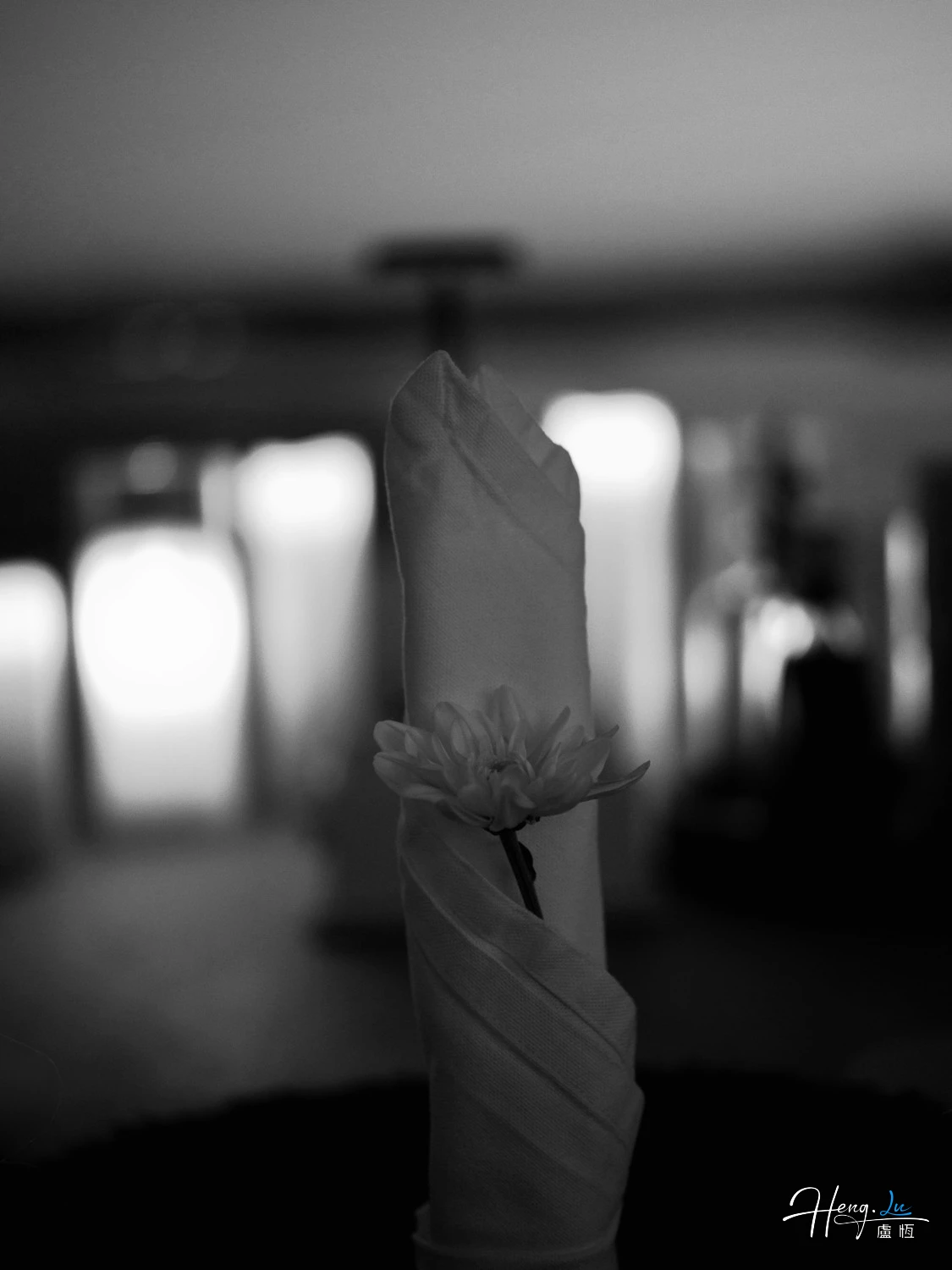 Black and White Folded Napkin Holding Single Flower in Elegant Setting