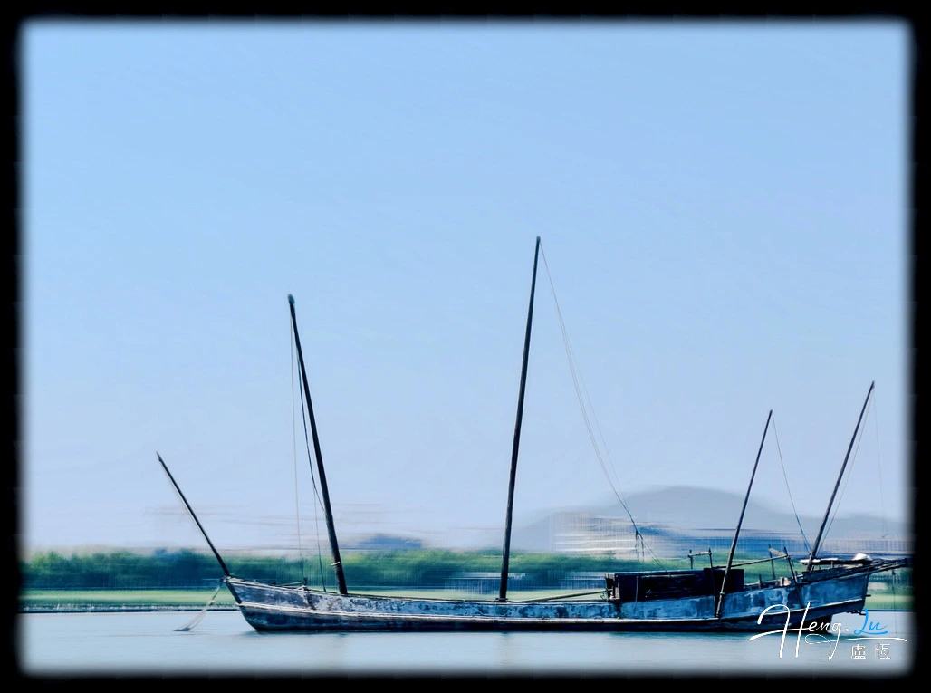 Wooden Sailboat On Calm Lake Under Blue Sky