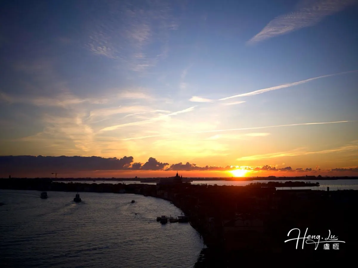 Sunset View Over River With Boats And Silhouetted City