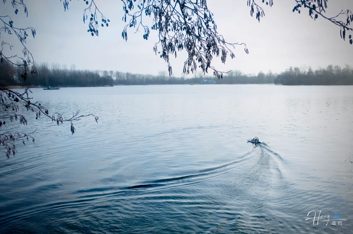 small-boat-on-calm-lake-with-bare-trees (1)
