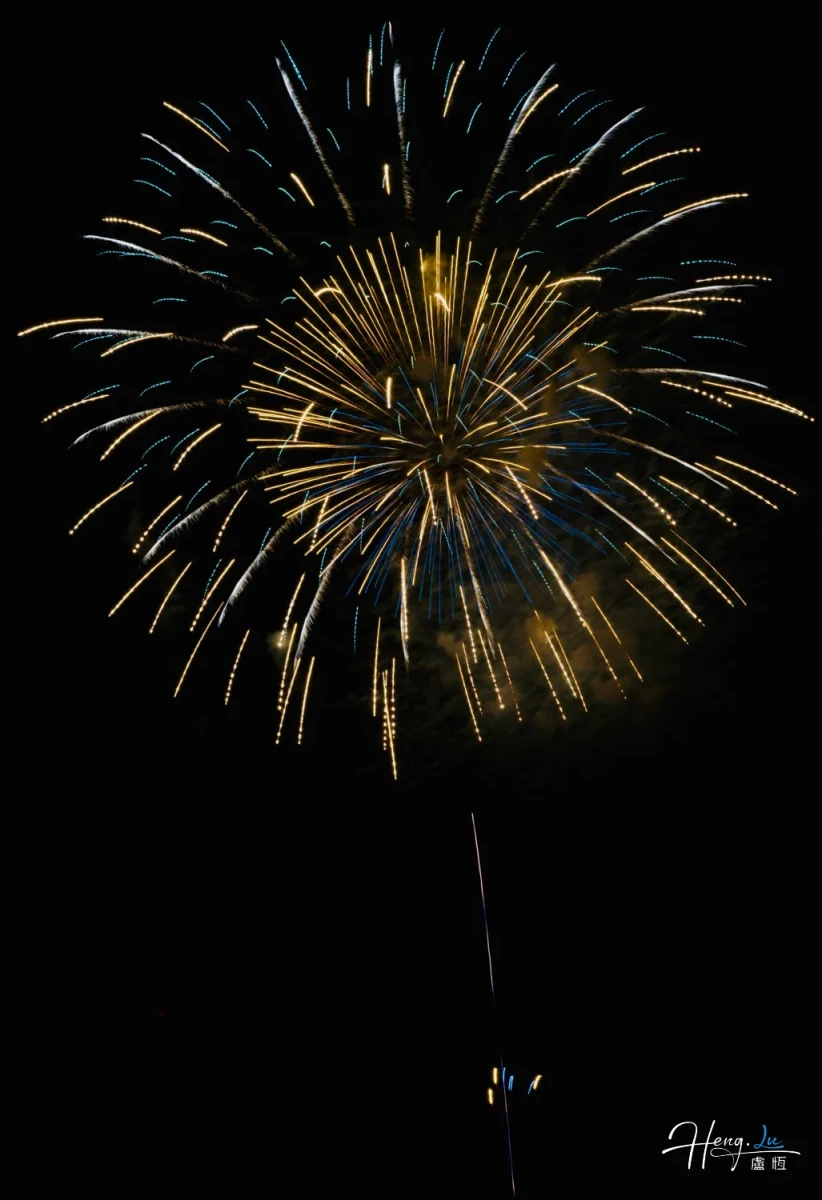 Golden And Blue Firework Bursts Gloriously Against Dark Midnight Sky