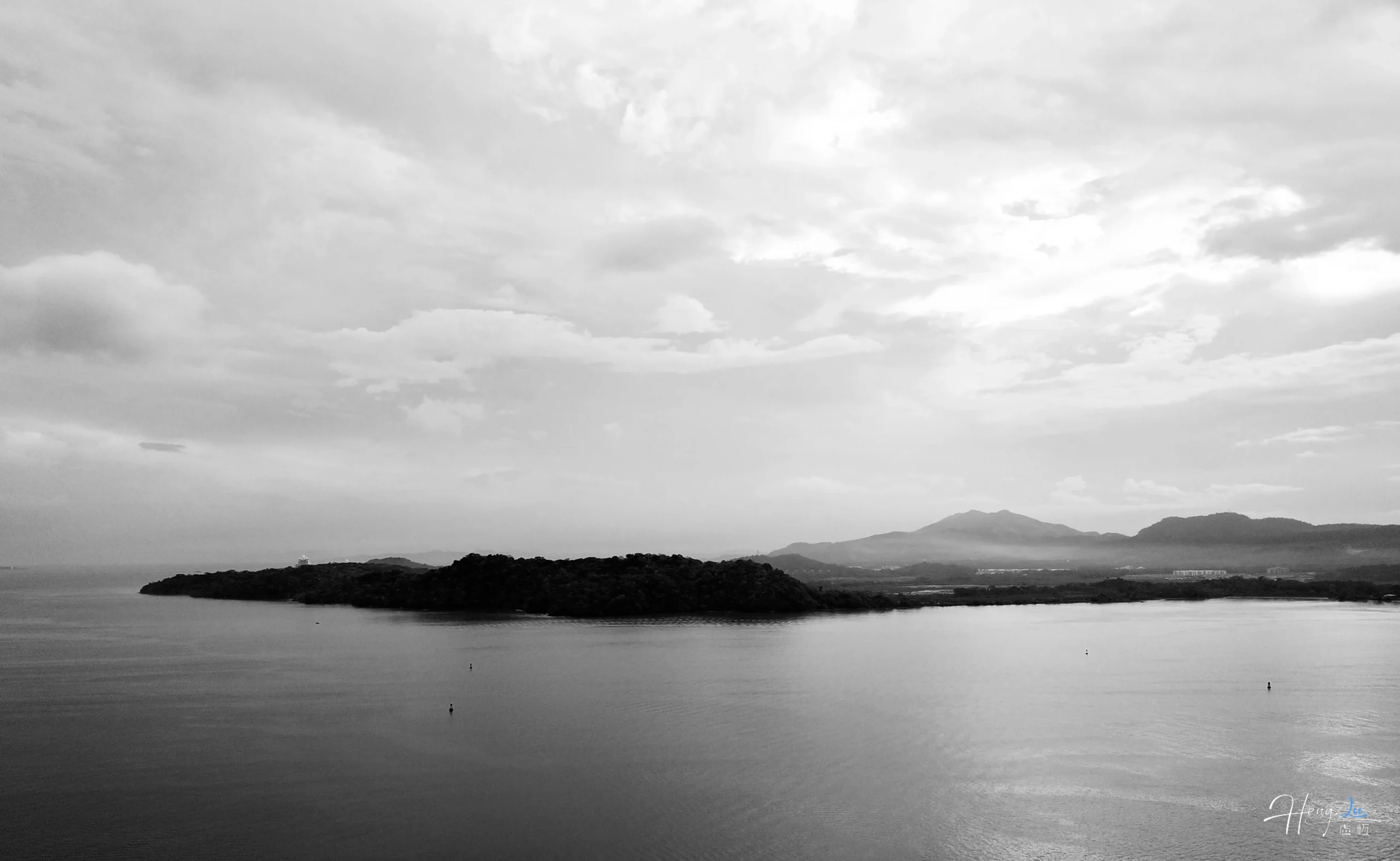 Black and White Seascape with Distant Island and Mountainous Horizon