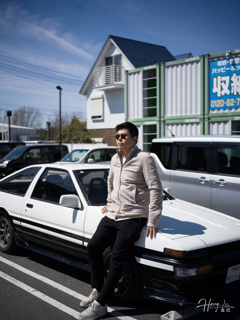 Lu Heng with classic car under clear sky