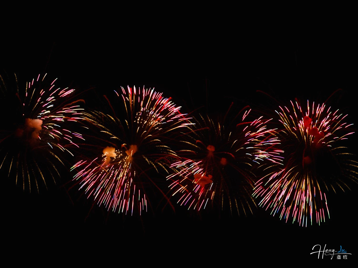 Red and gold fireworks exploding across dark sky