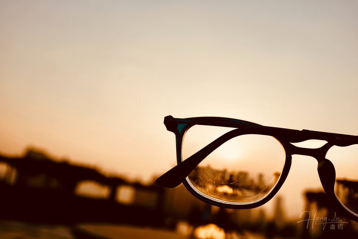 A Pair Of Eyeglasses Reflecting A Sunset