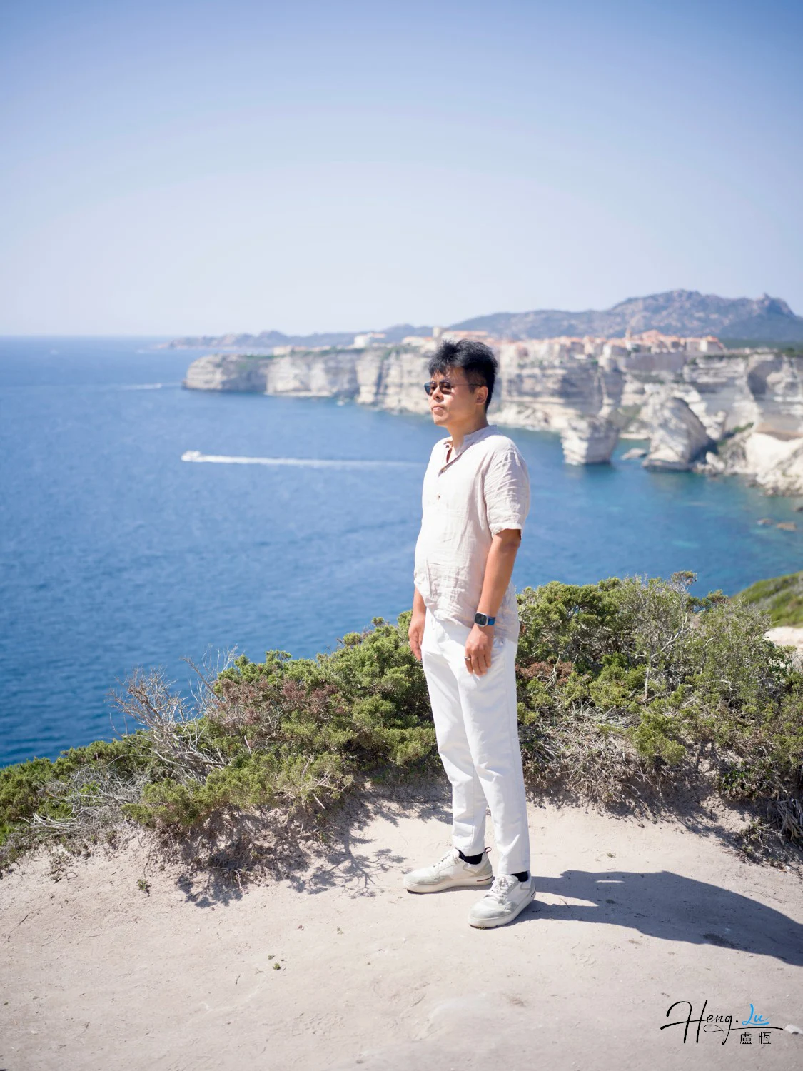 Luheng Standing on Cliff Overlooking Blue Sea