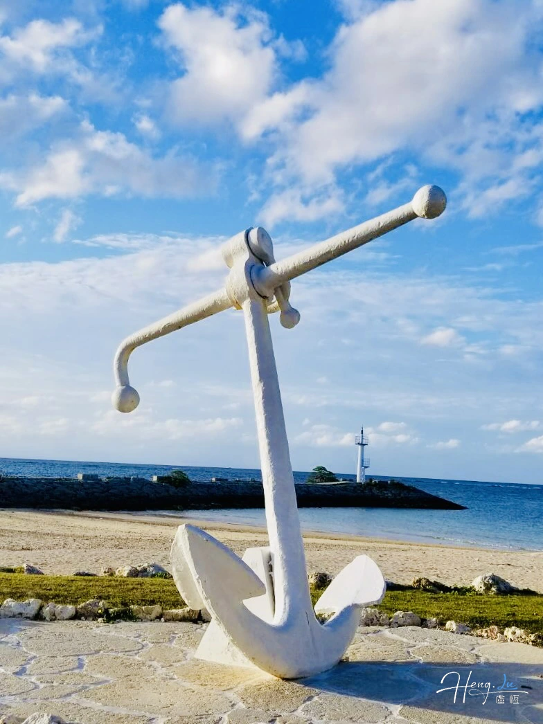 White Anchor Sculpture On Beach Under Blue Sky