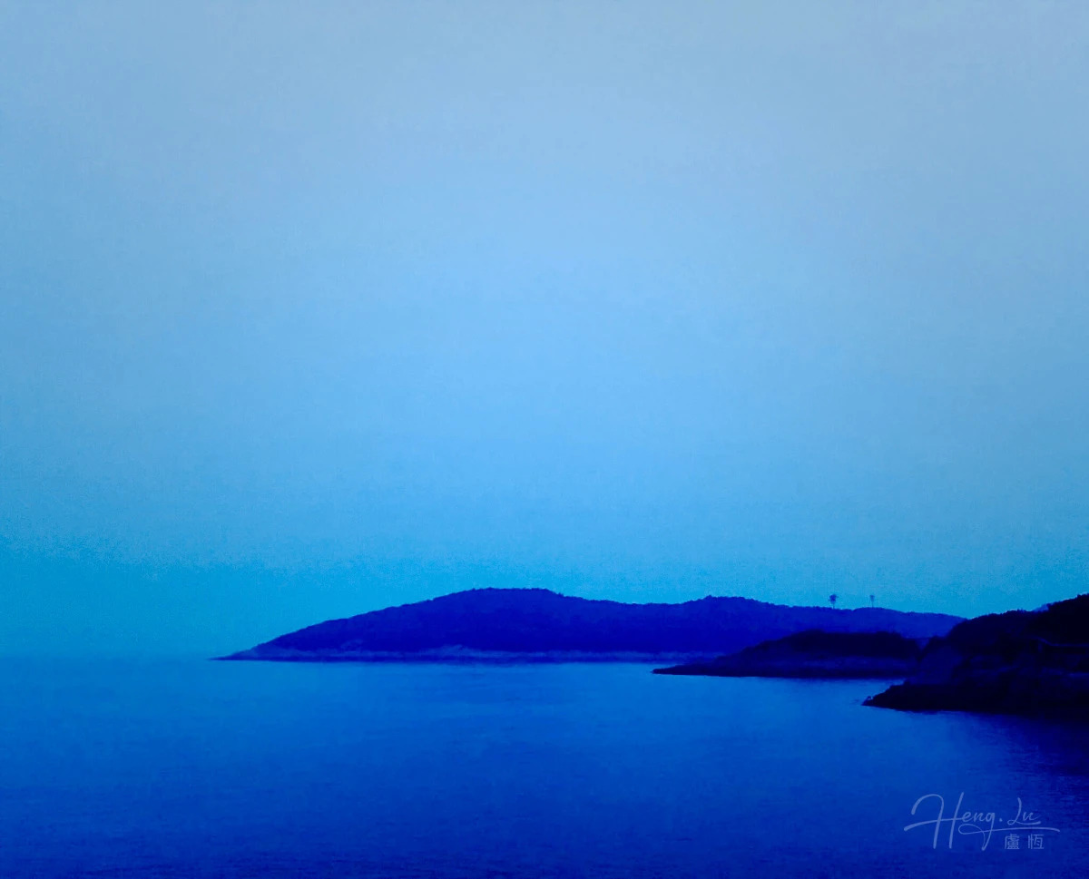 Enchanting Blue-Toned Seascape with Silhouetted Coastal Hills