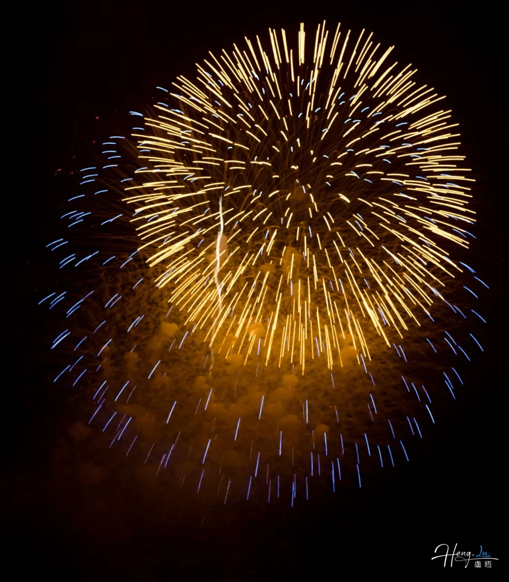 Golden And Blue Fireworks Burst Brightly In Night Sky