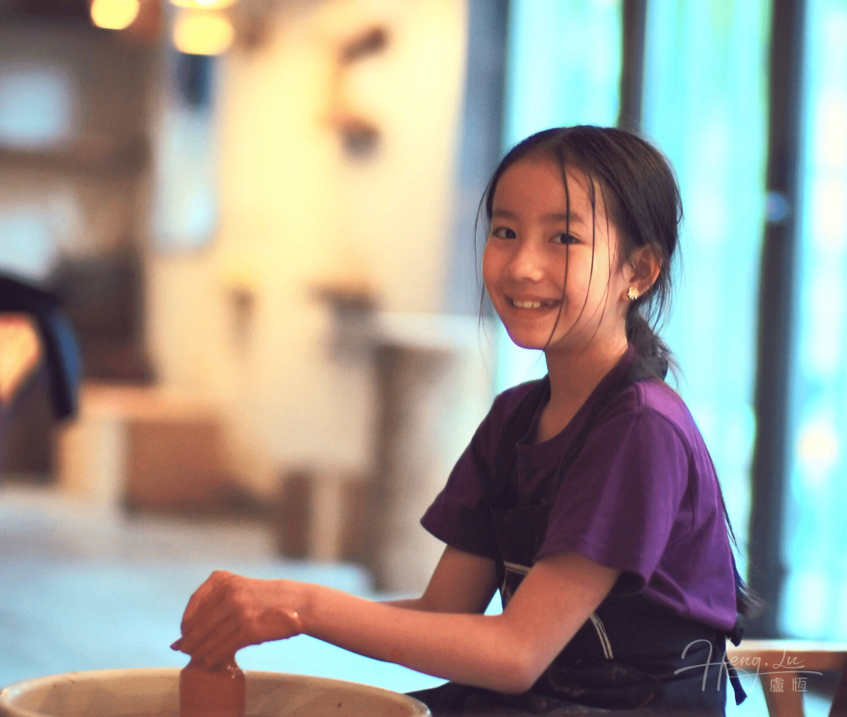 Girl Smiling While Shaping Clay In Pottery Class