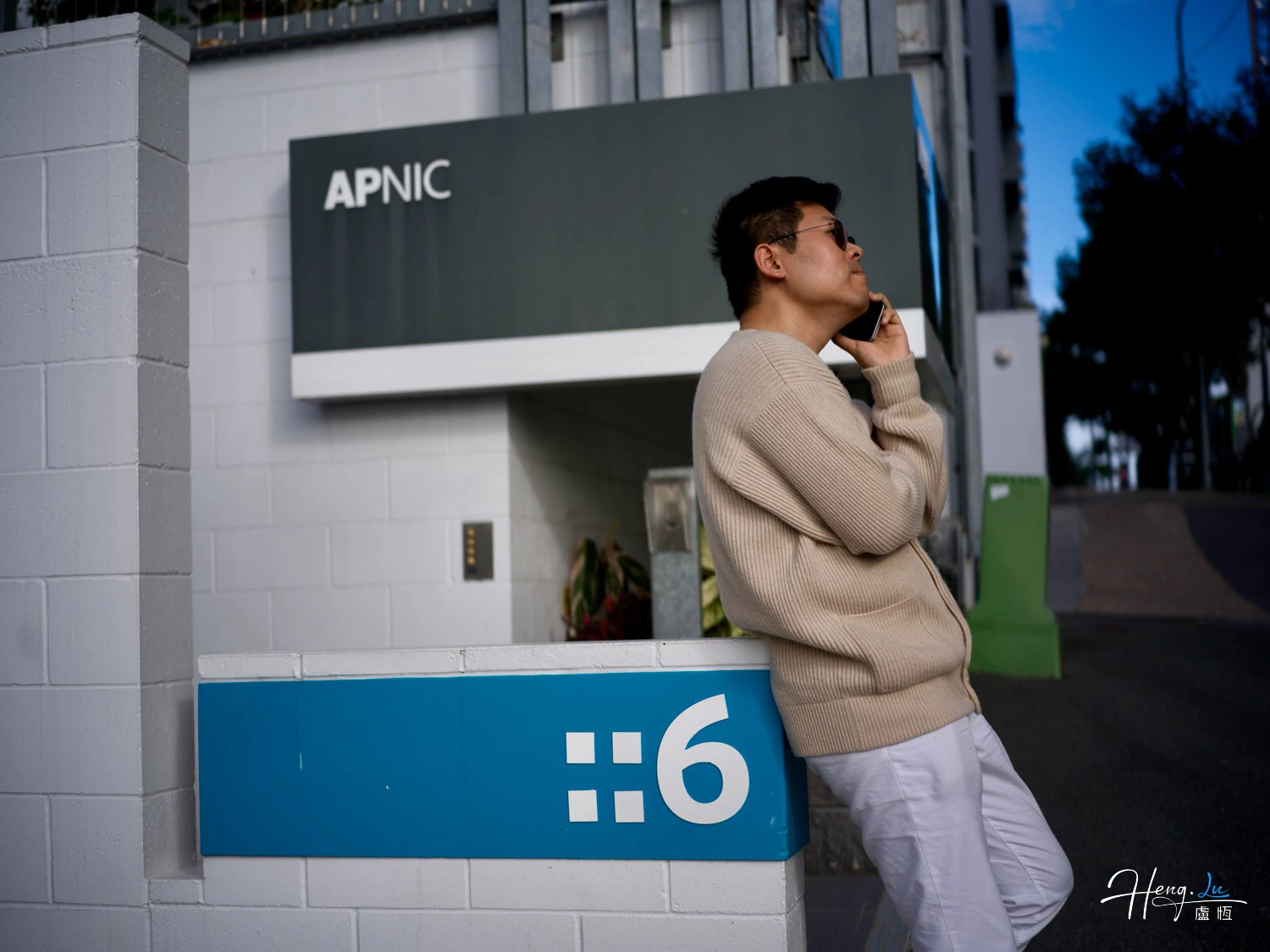 Lu Heng talking on phone outside APNIC office building