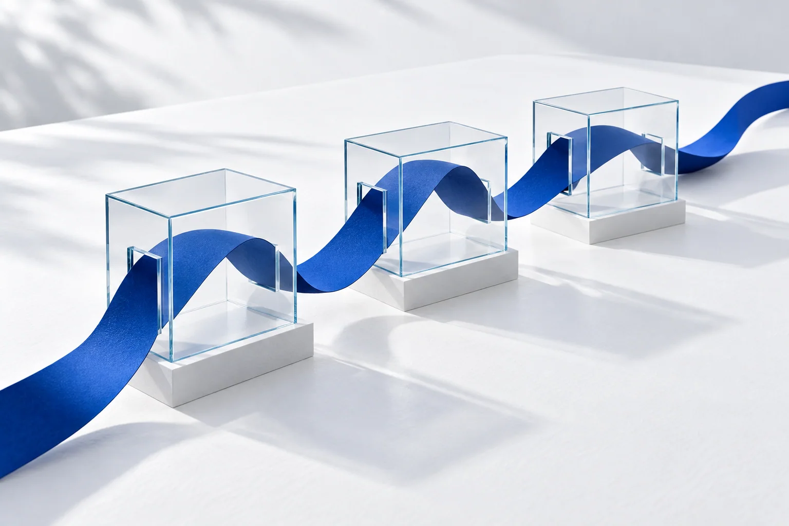 Conceptual illustration of one blue ribbon passing through three separate transparent cases.