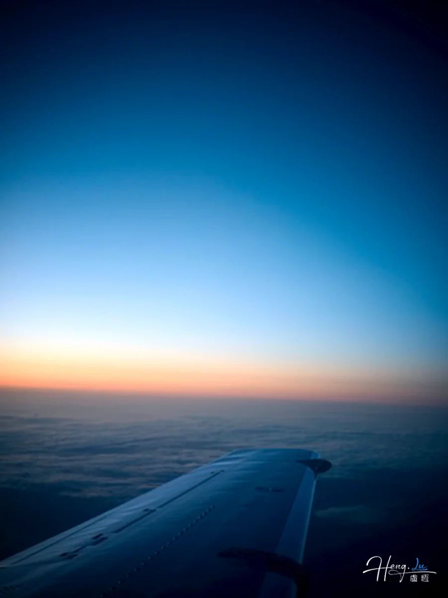 Airplane Wing Above Clouds During Sunrise