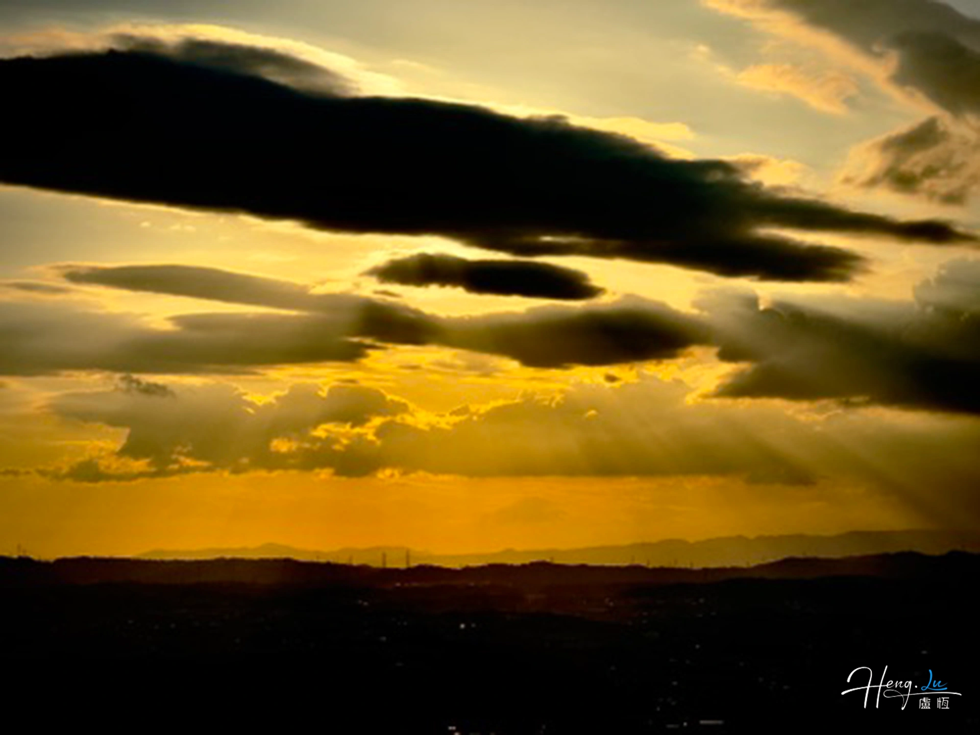 Golden sunset rays through dramatic clouds