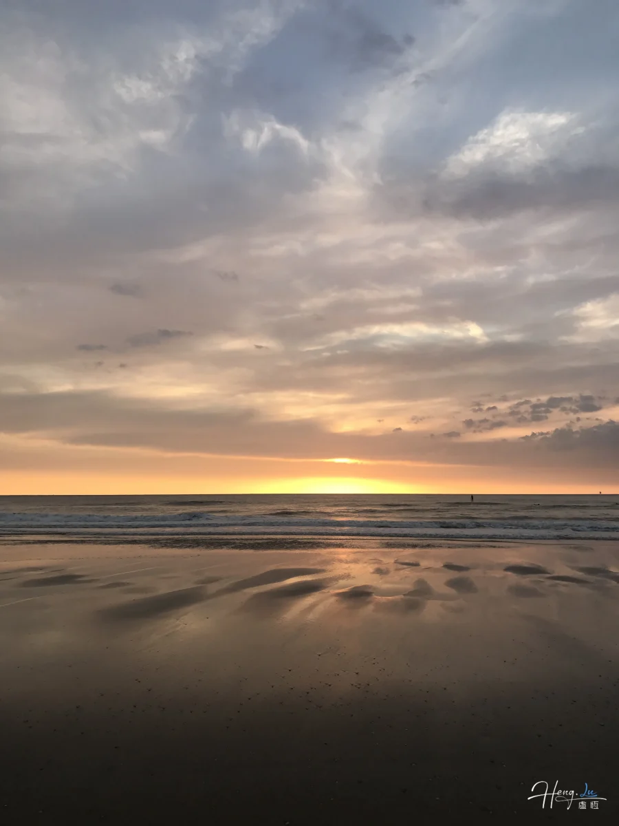 Pastel Sunset Reflecting On Calm Beach Shore