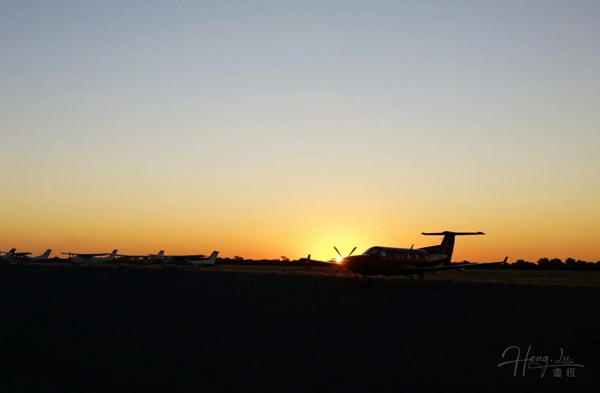Airplanes Parked on Runway with African Sunset in Background
