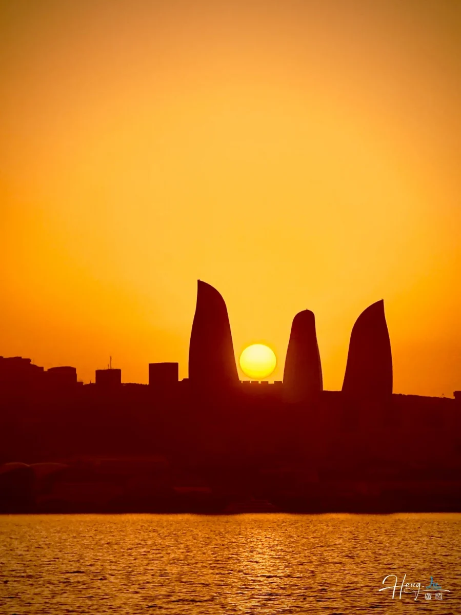 Sunset Over Modern City Silhouette By Water
