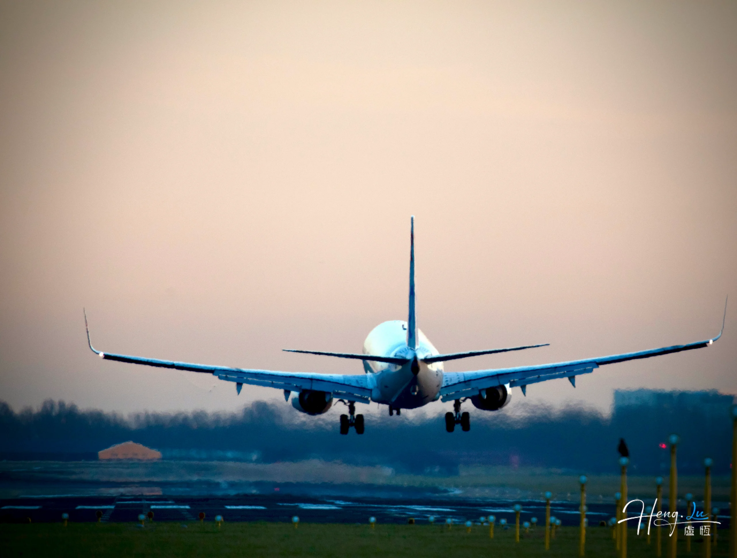 Airplane taking off at dawn