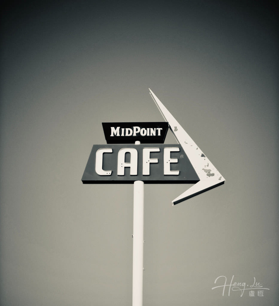A Vintage Midpoint Cafe Sign Against A Sky