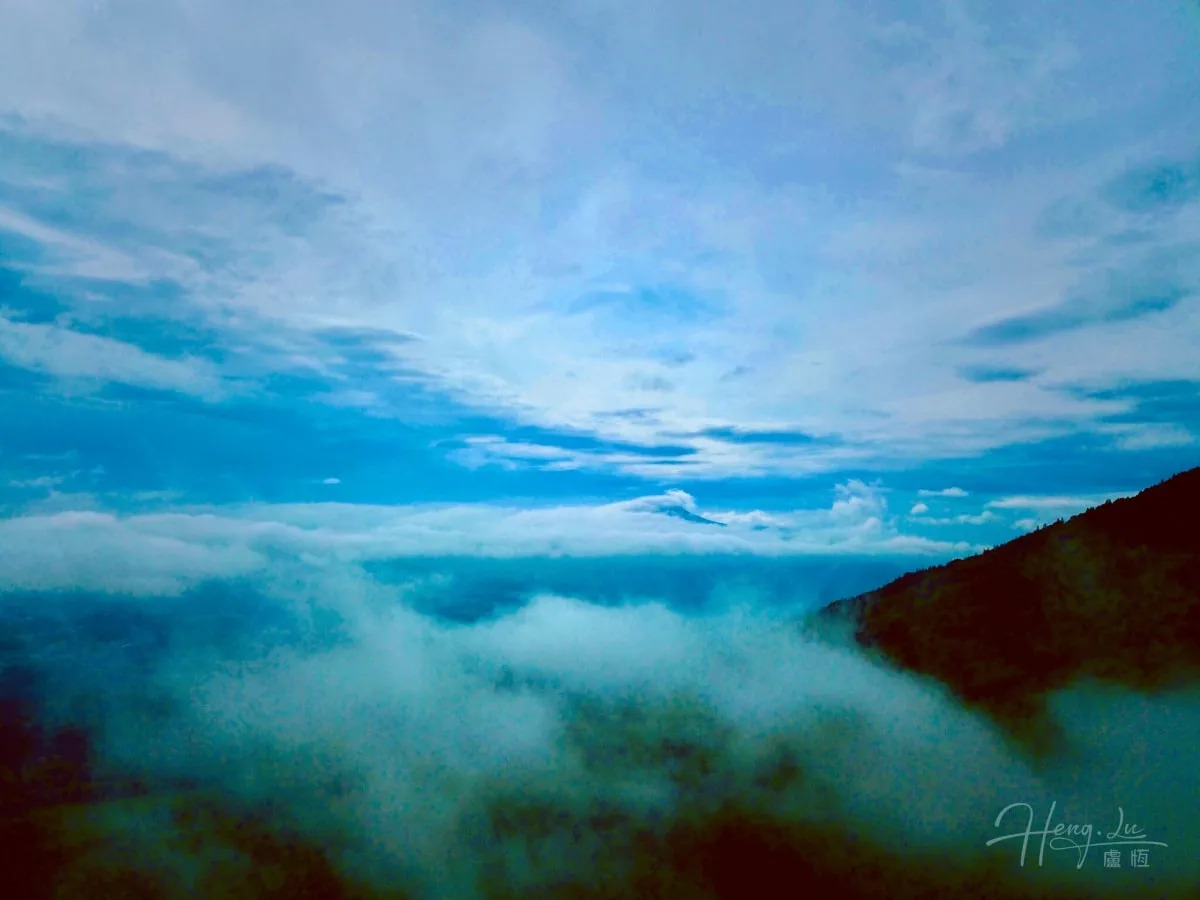 Las nubes se reúnen sobre una cordillera bajo el cielo azul.