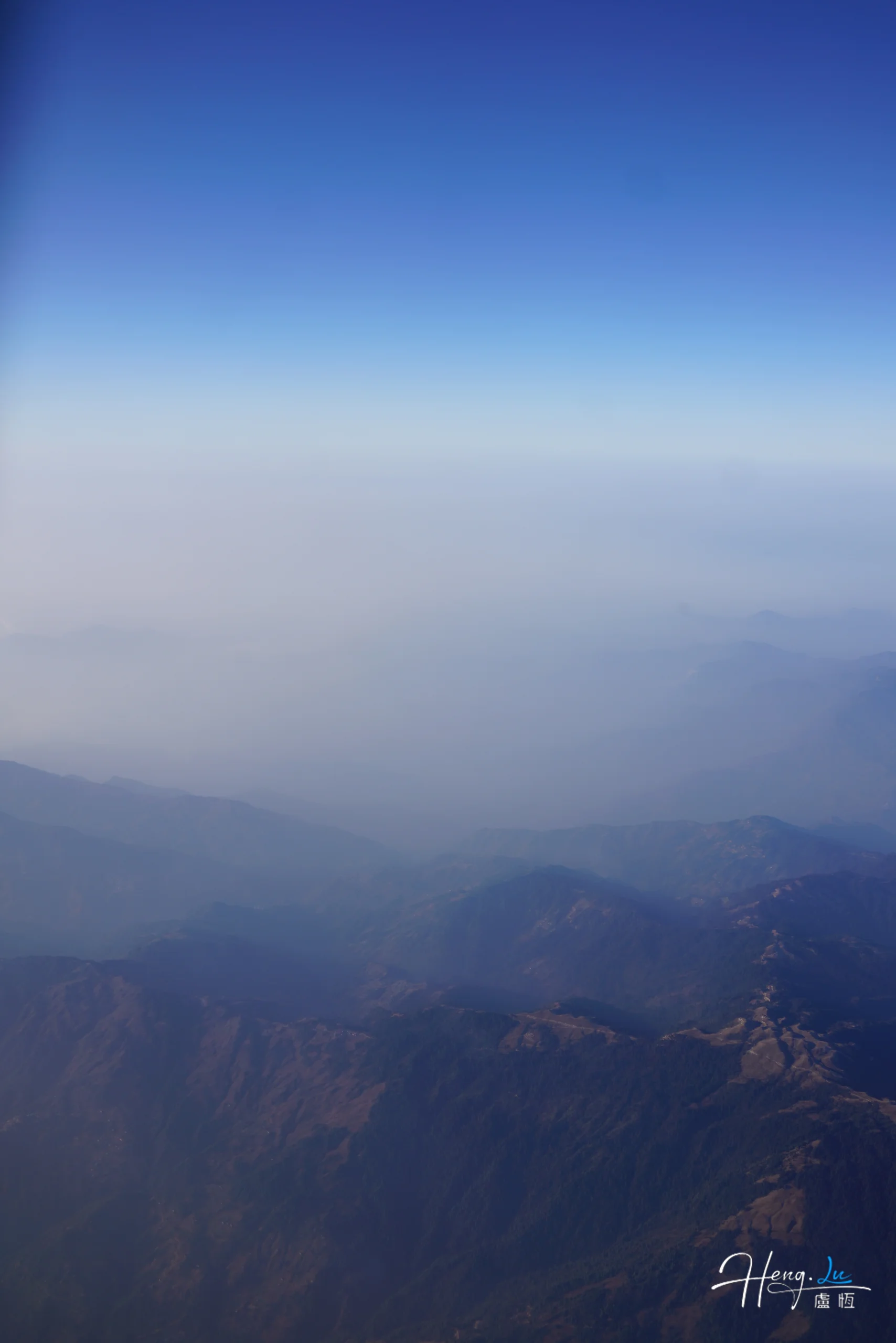 Misty mountain range under blue sky