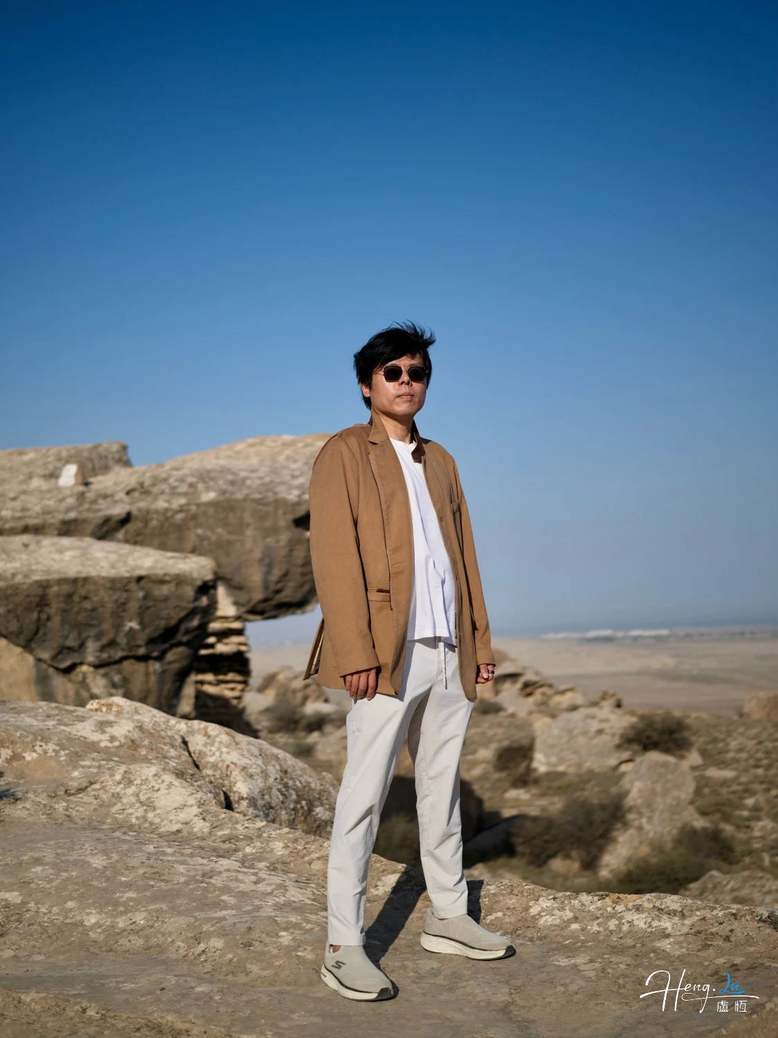Luheng-standing-on-sunlit-rocky-plateau