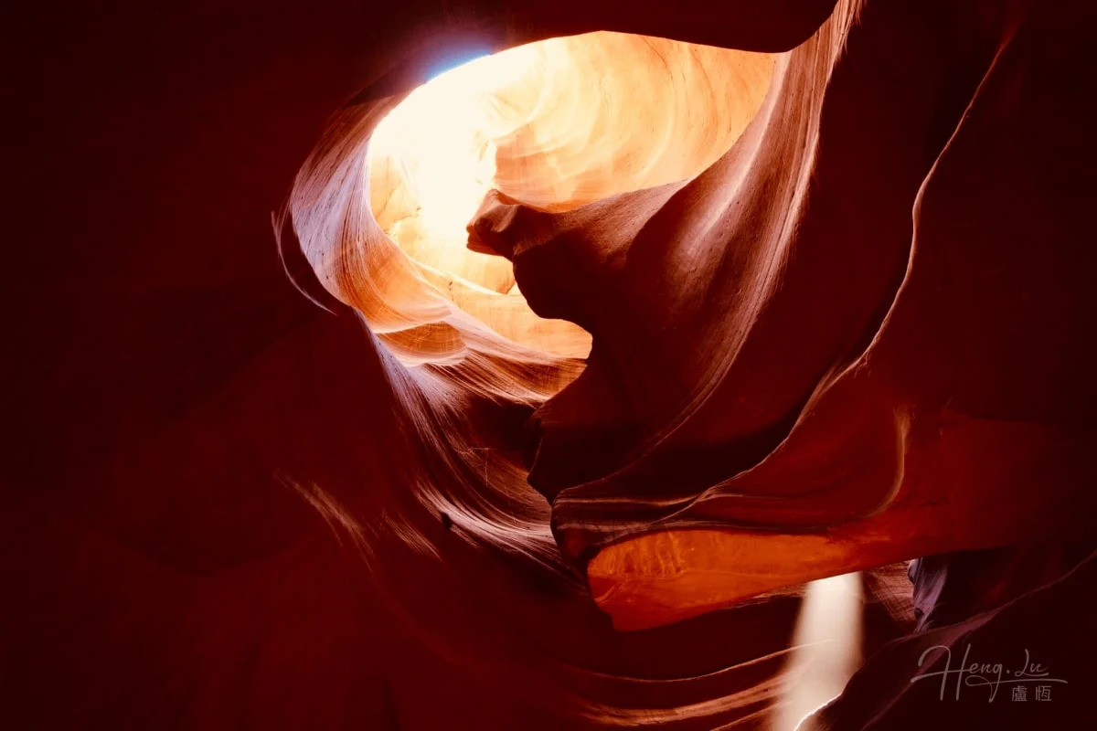 Una forma roja iluminada por el sol llena la imagen de pliegues y texturas.