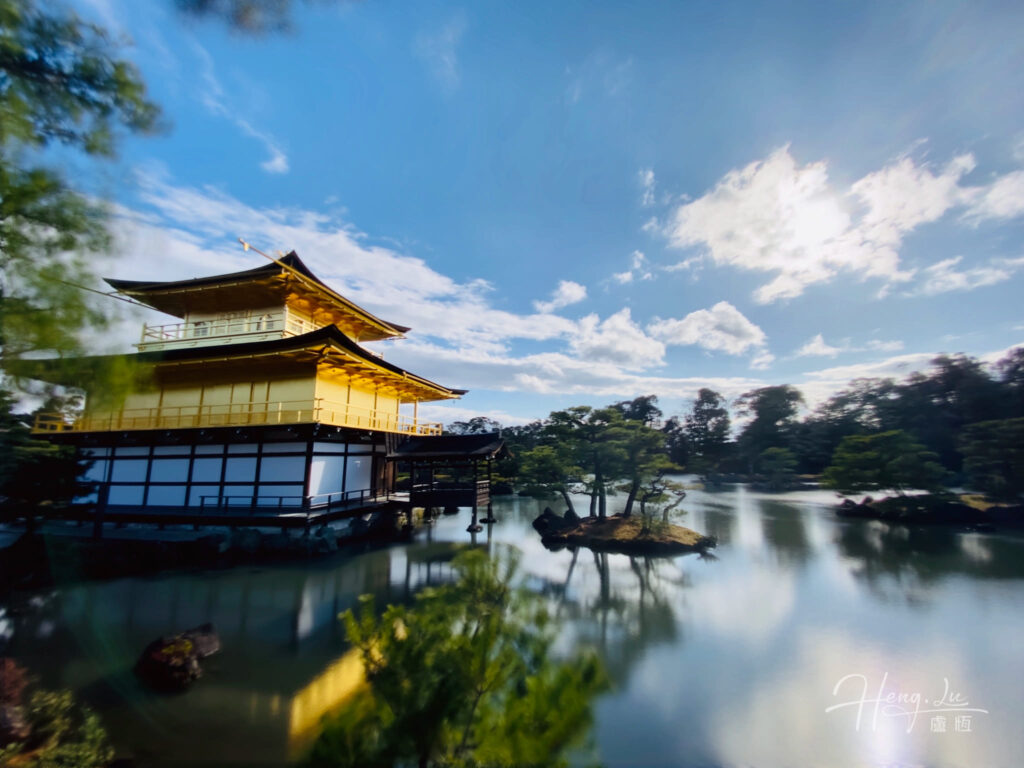 A golden pavilion with Barren Trees at the Chilly Lake Under Blue Sky