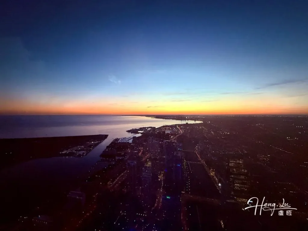 Sunset Over Coastal City Skyline With Calm Waters City-coastline-at-sunset-with-colorful-skyline-view