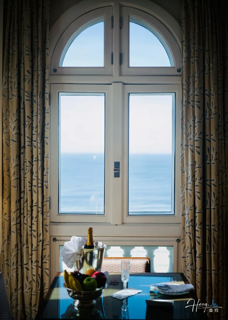 Window Framing the Horizon Elegant-window-view-overlooking-ocean-with-fruits-and-champagne