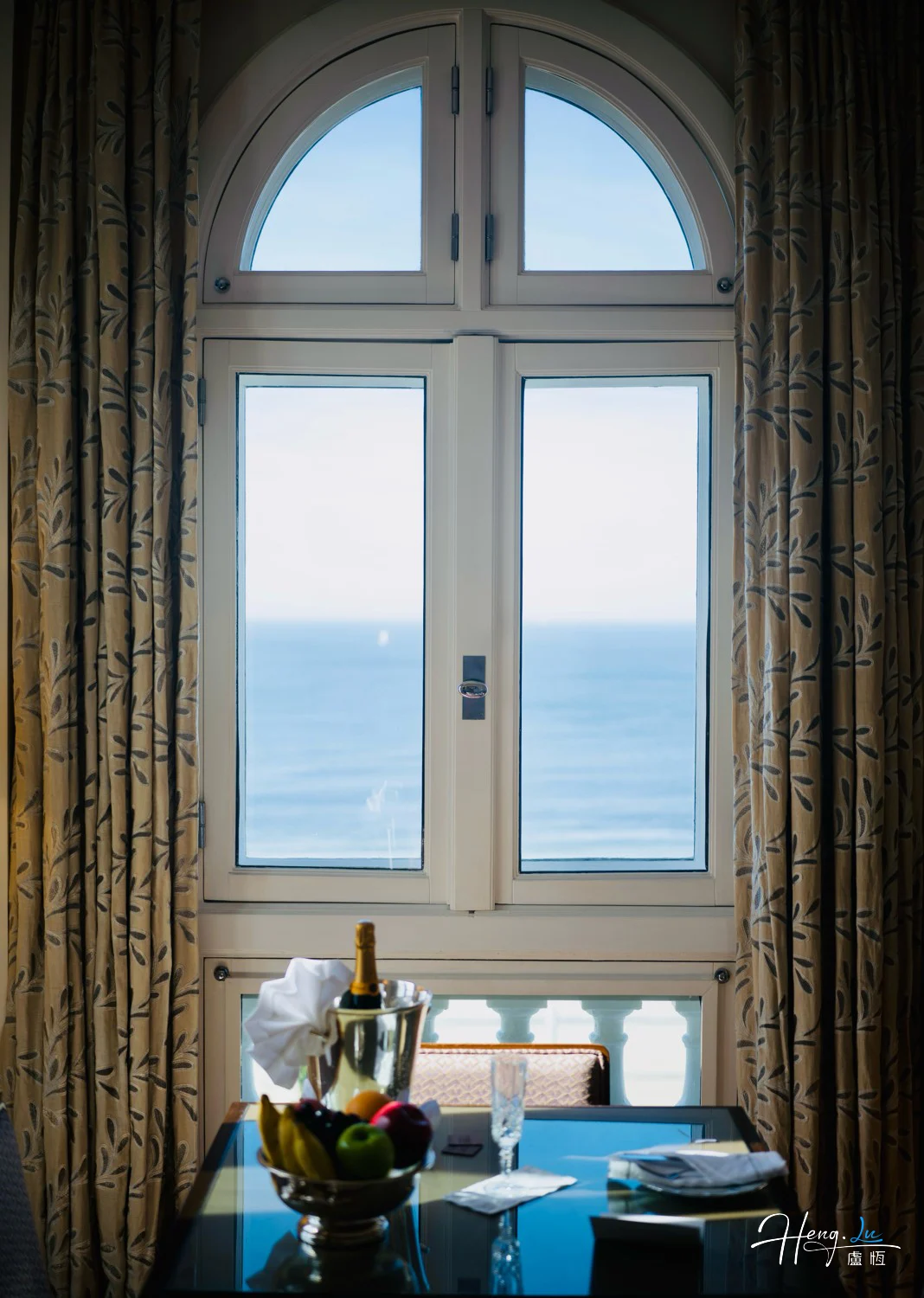 Elegant-window-view-overlooking-ocean-with-fruits-and-champagne