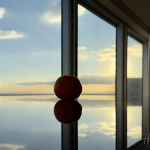 Sunset reflection with orange framed by glass windows Orange-on-reflective-table-with-Tokyo-sunset-view