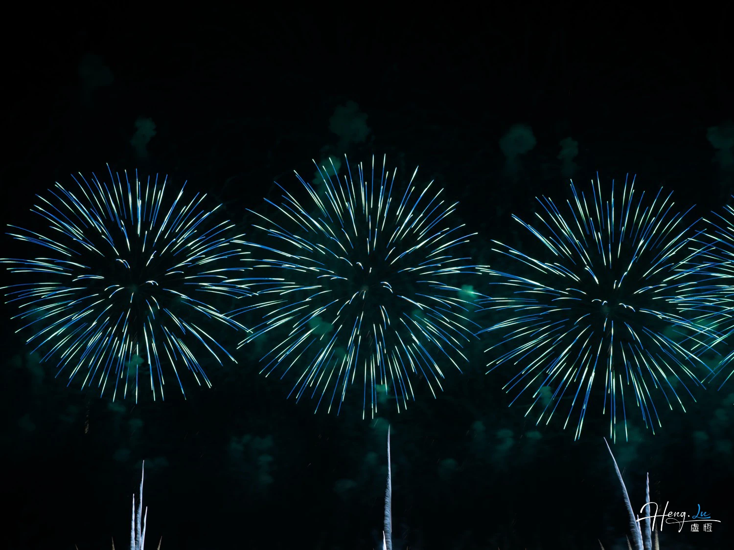 Three Blue Fireworks Bursting in Night Sky