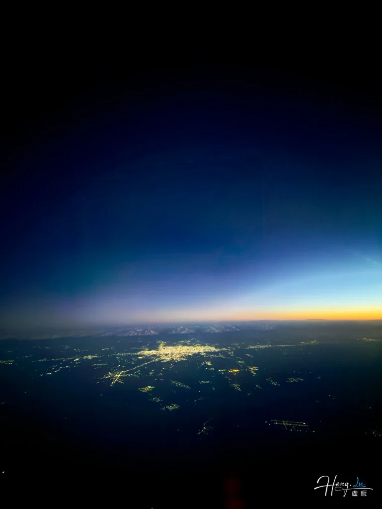 Edge of night seen from above City-lights-glowing-under-deep-twilight-sky