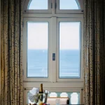 Window Framing the Horizon Elegant-window-view-overlooking-ocean-with-fruits-and-champagne