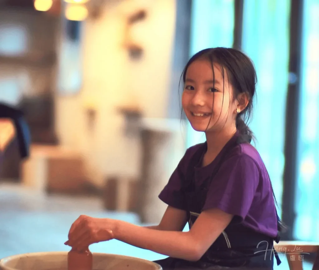The Joy of Creation Girl-smiling-while-shaping-clay-in-pottery-class