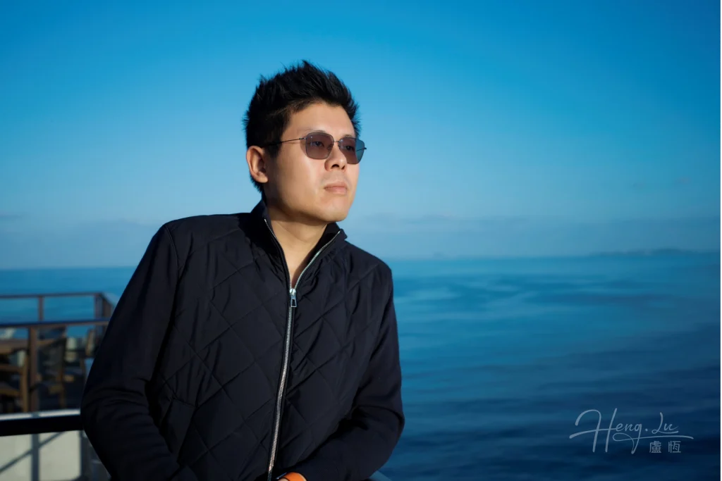 Lu Heng by the sea under clear blue horizon Luheng-leaning-on-balcony-with-ocean-view