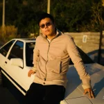 Between drive and dream Luheng-leaning-on-white-car-under-sunset-light