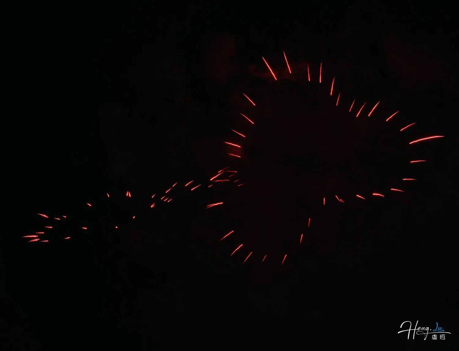 Red-firework-trails-forming-heart-shape-in-dark-sky
