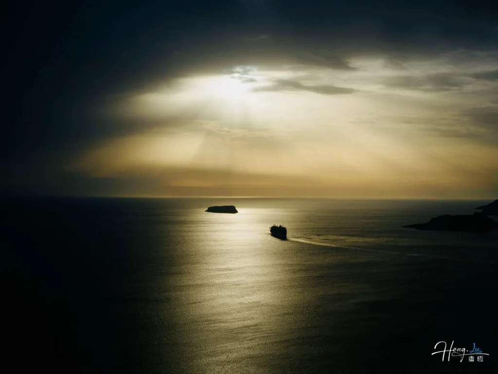 Ship Sailing Under Dramatic Sunset Sky with Sunrays and Island Ship-sailing-under-dramatic-sunset-sky