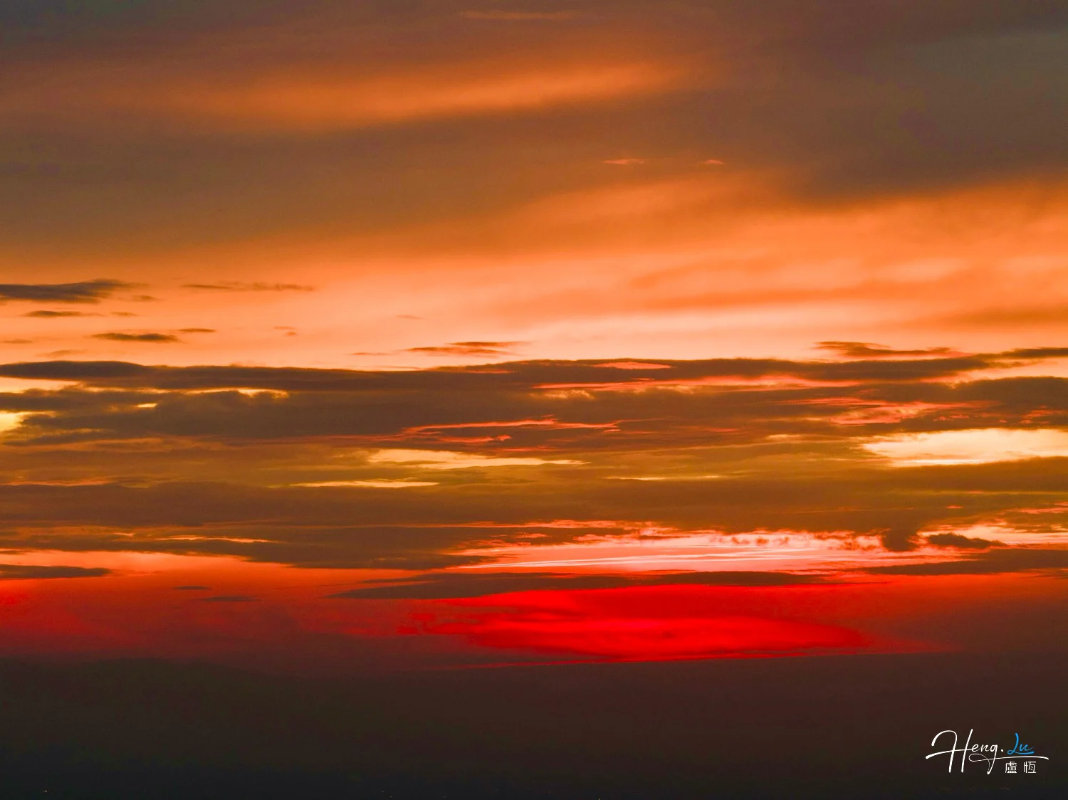 Vibrant-orange-and-red-sunset-over-cloudy-evening-sky