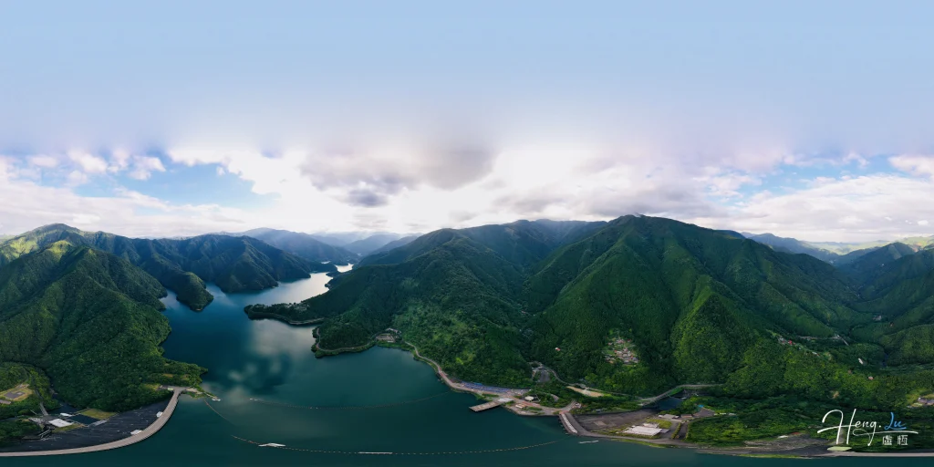 Aerial View of Winding Lake Among Lush Green Mountain Ranges aerial-view-of-winding-lake-among-green-mountain-ranges