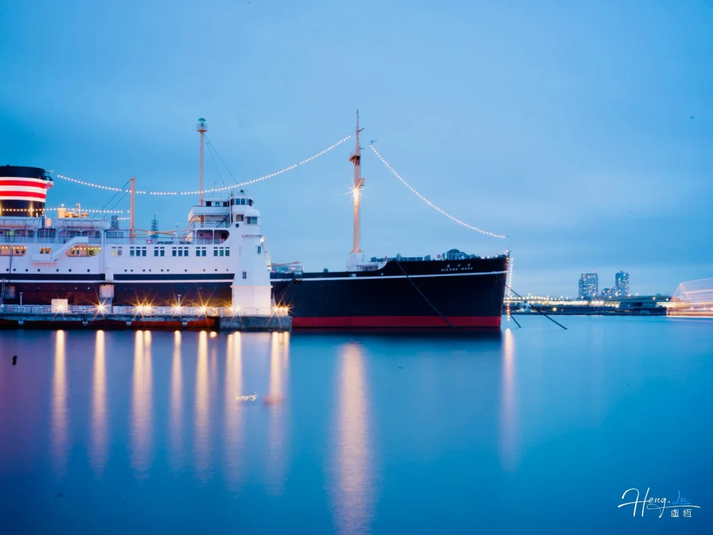 Evening View of Illuminated Docked Ship with Reflections on Calm Water Evening-view-of-illuminated-docked-ship