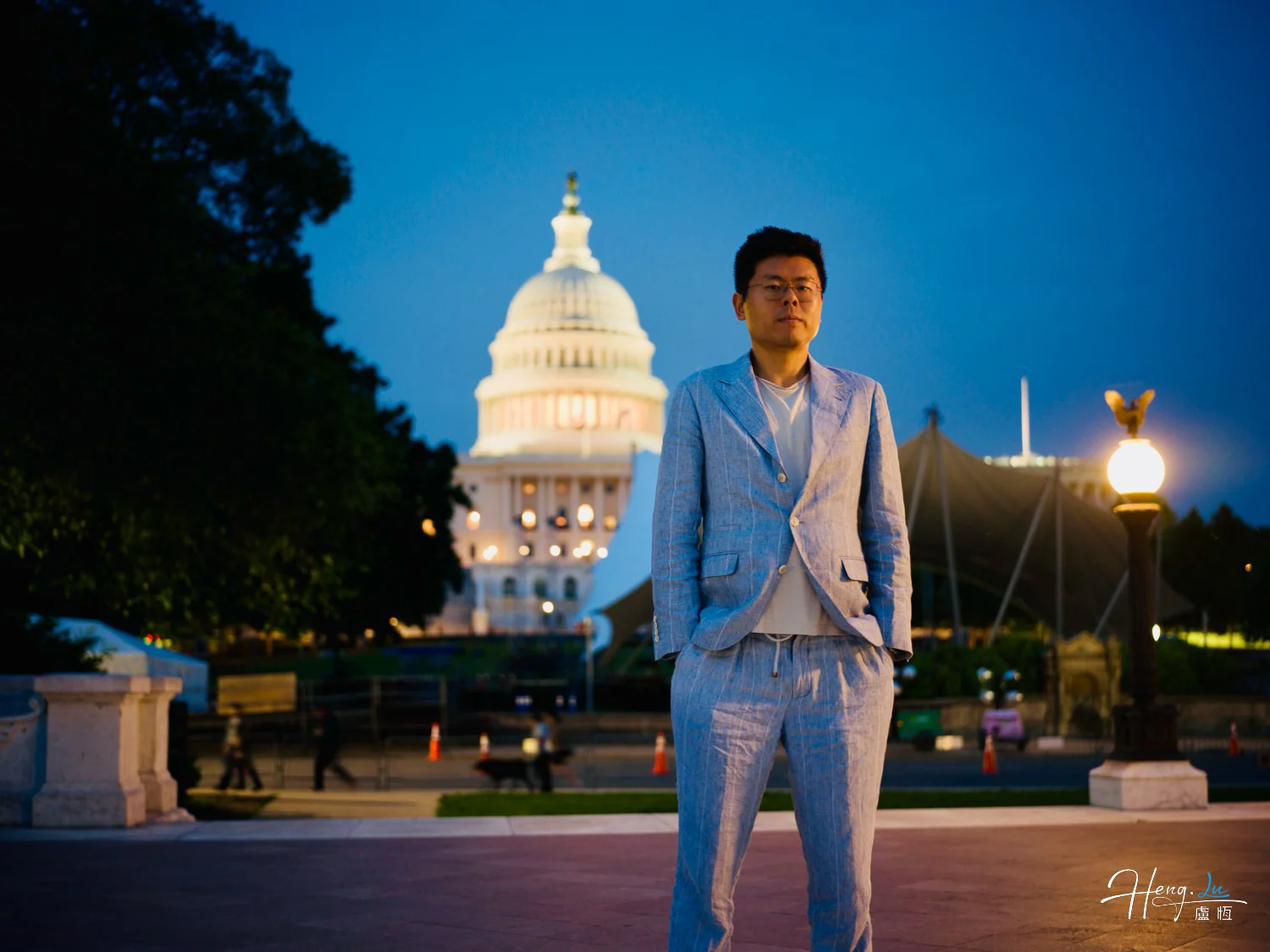Lu Heng in Light Suit Standing at Night with US Capitol Building in Background