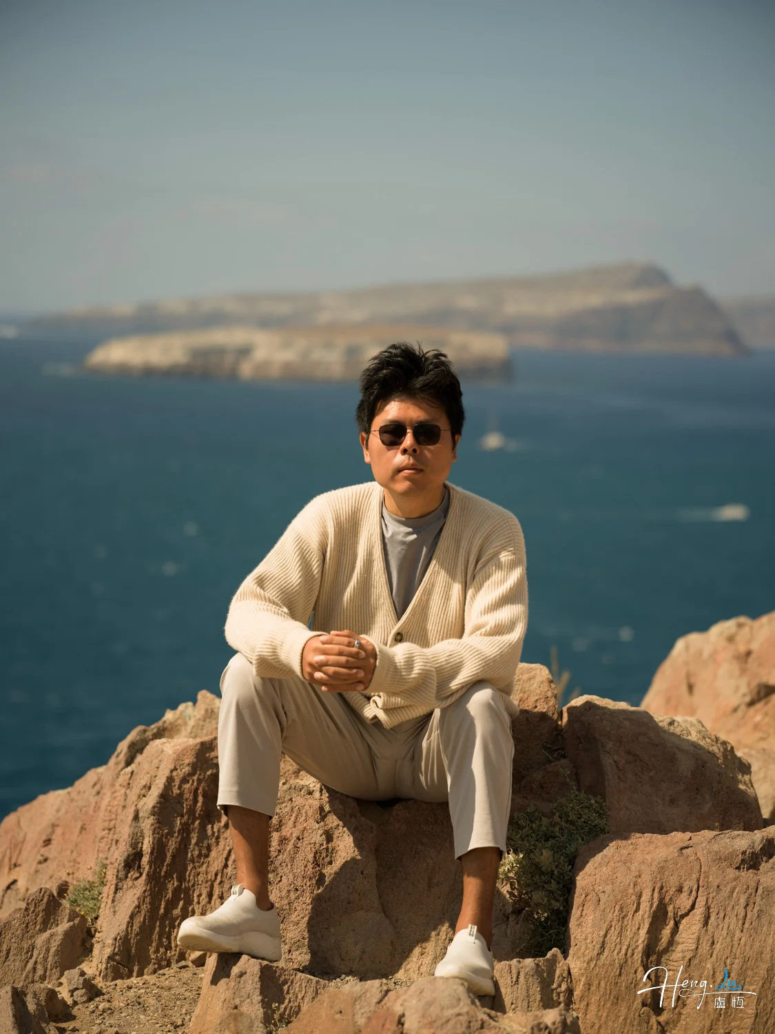 Luheng-sitting-on-rocky-cliff-by-sea