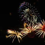 gold-and-red-fireworks-bursting-above-dark-sky