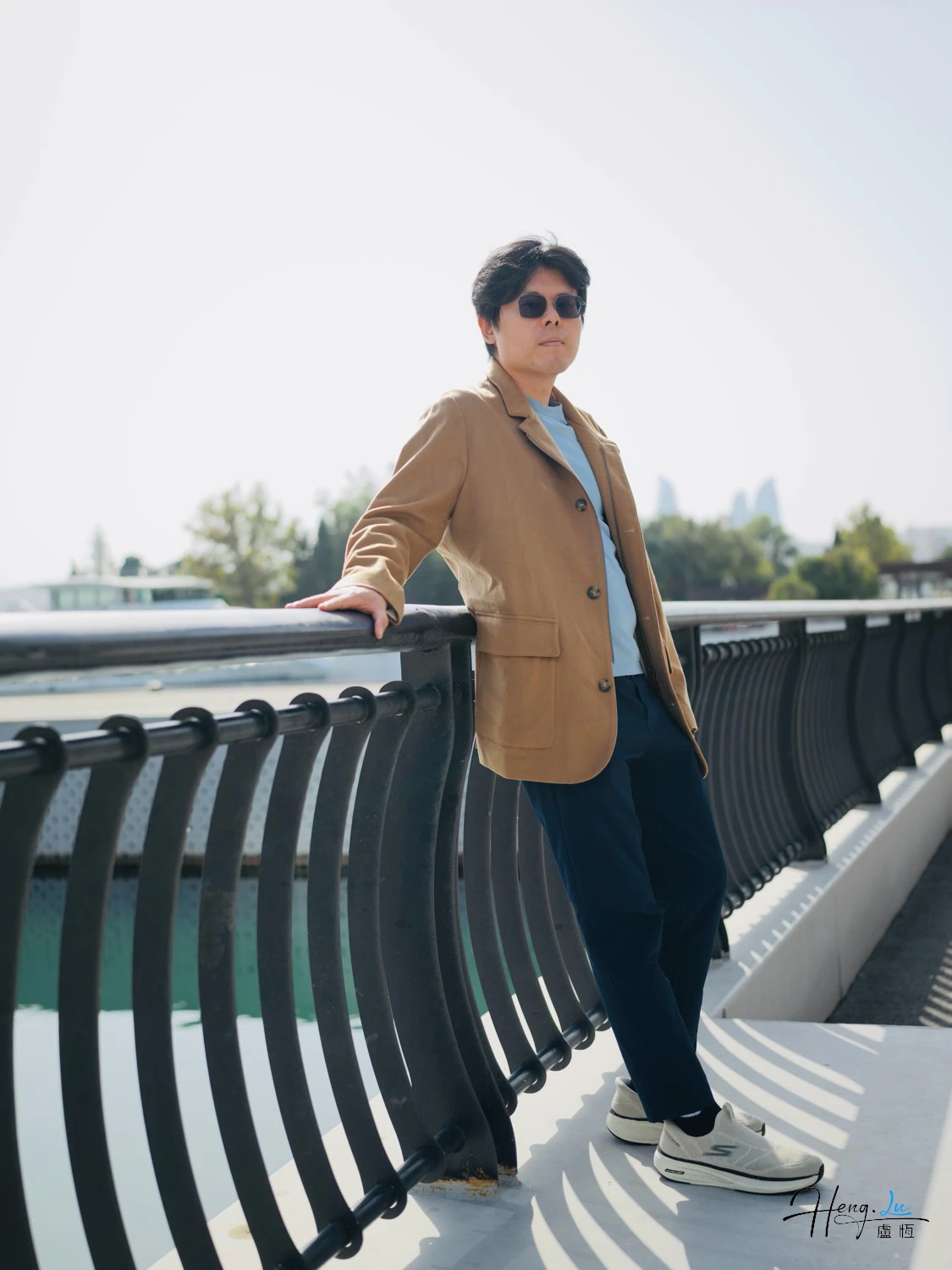 luheng-leaning-on-bridge-railing-under-bright-sunlight