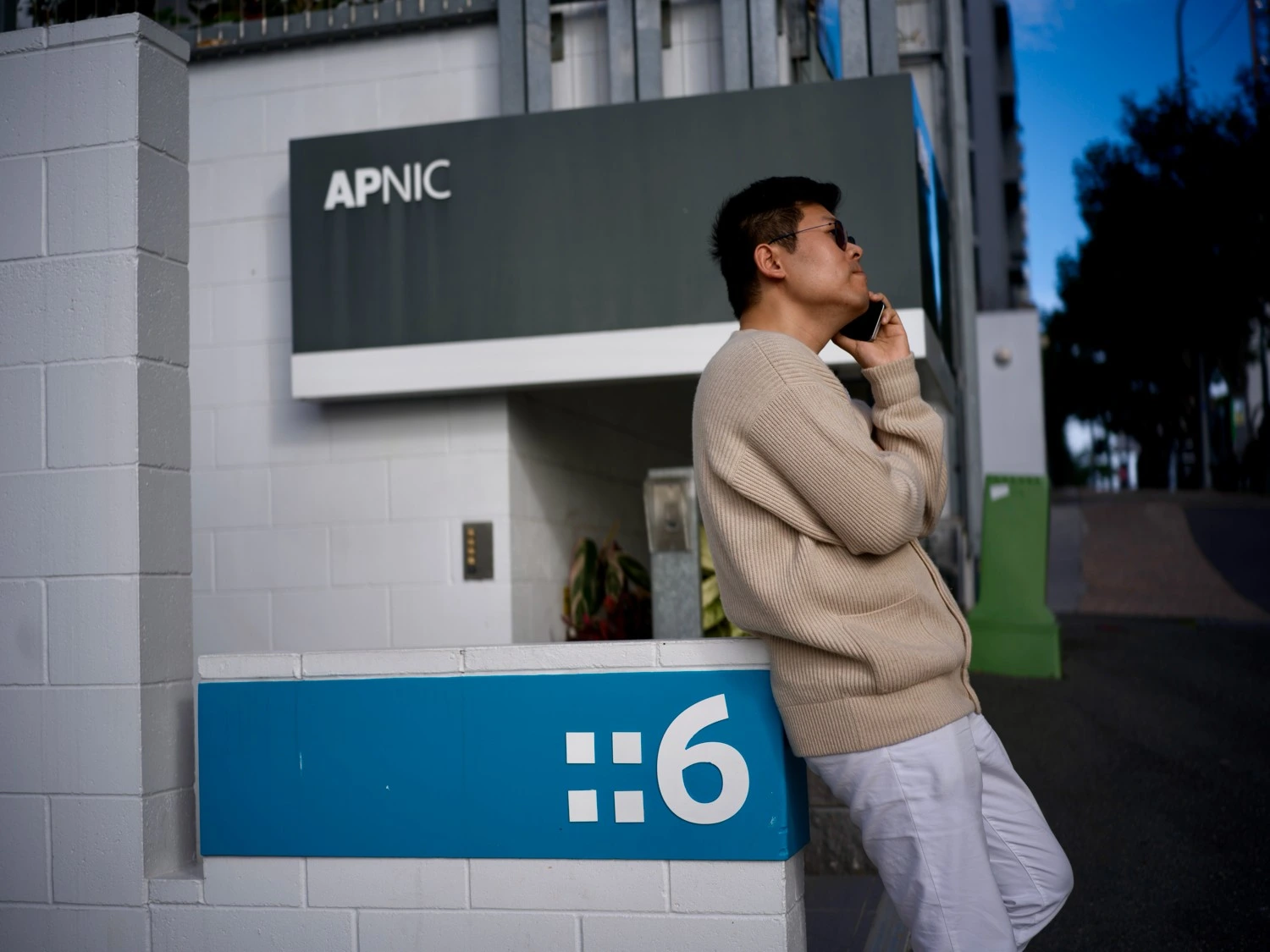 Lu Heng talking on phone outside APNIC office building